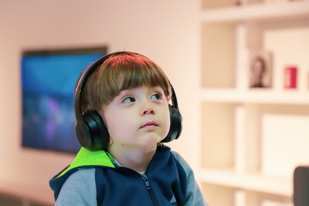 Young child wearing headphones and looking up during a hearing screening