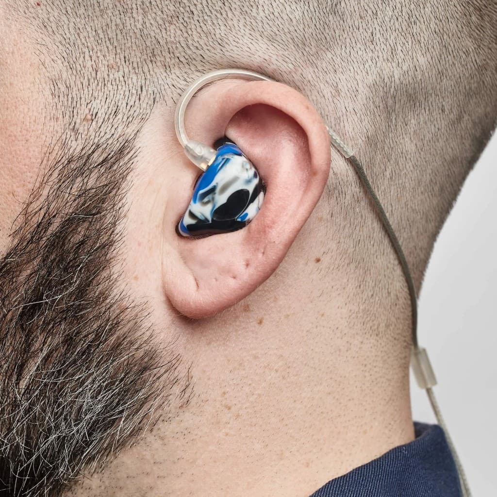 Side profile of a custom-molded in-ear monitor shell fitted in the ear with clear over-ear cable